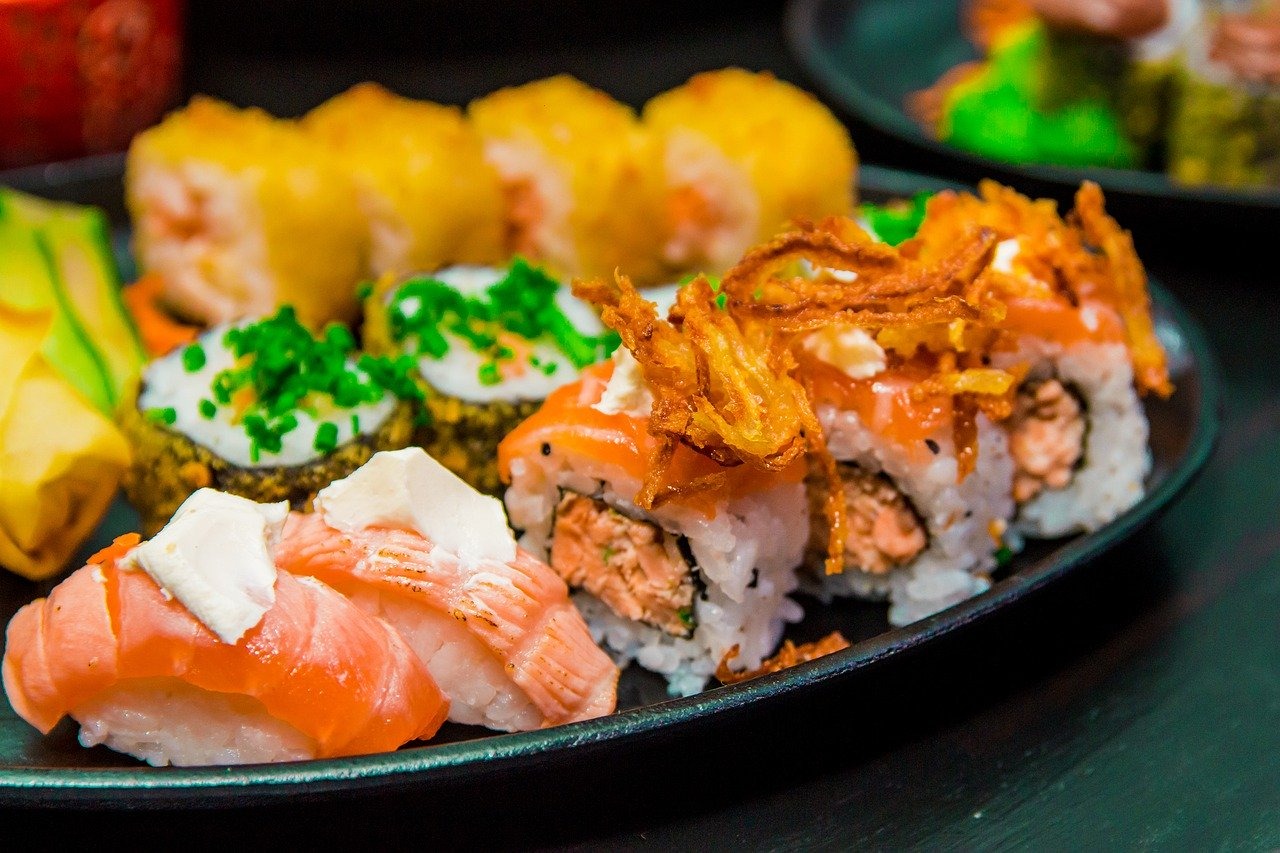 Sushi rolls and nigiri arranged on a black platter