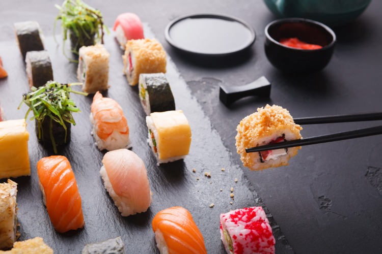 Sushi and maki arranged on a dark serving surface